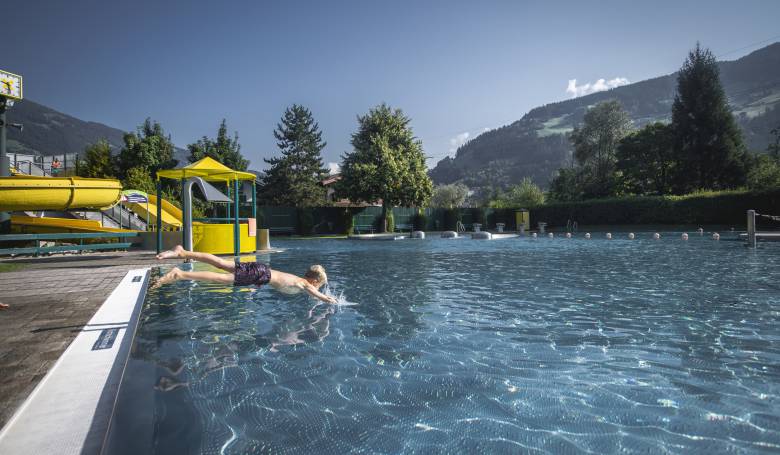 Junge springt ins Freibad in Mayrhofen im Zillertal